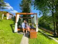 Para zakochanych na łóżku pod baldachimem, idealny pomysł na weekend w otoczeniu zieleni i strumyka.