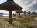 Rodzina spaceruje nad zalewem Radzanów, pod strzechami drewnianych wiat.