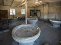 Wnętrze muzeum Stutthof z kamiennymi kadziami, które służyły do prania.