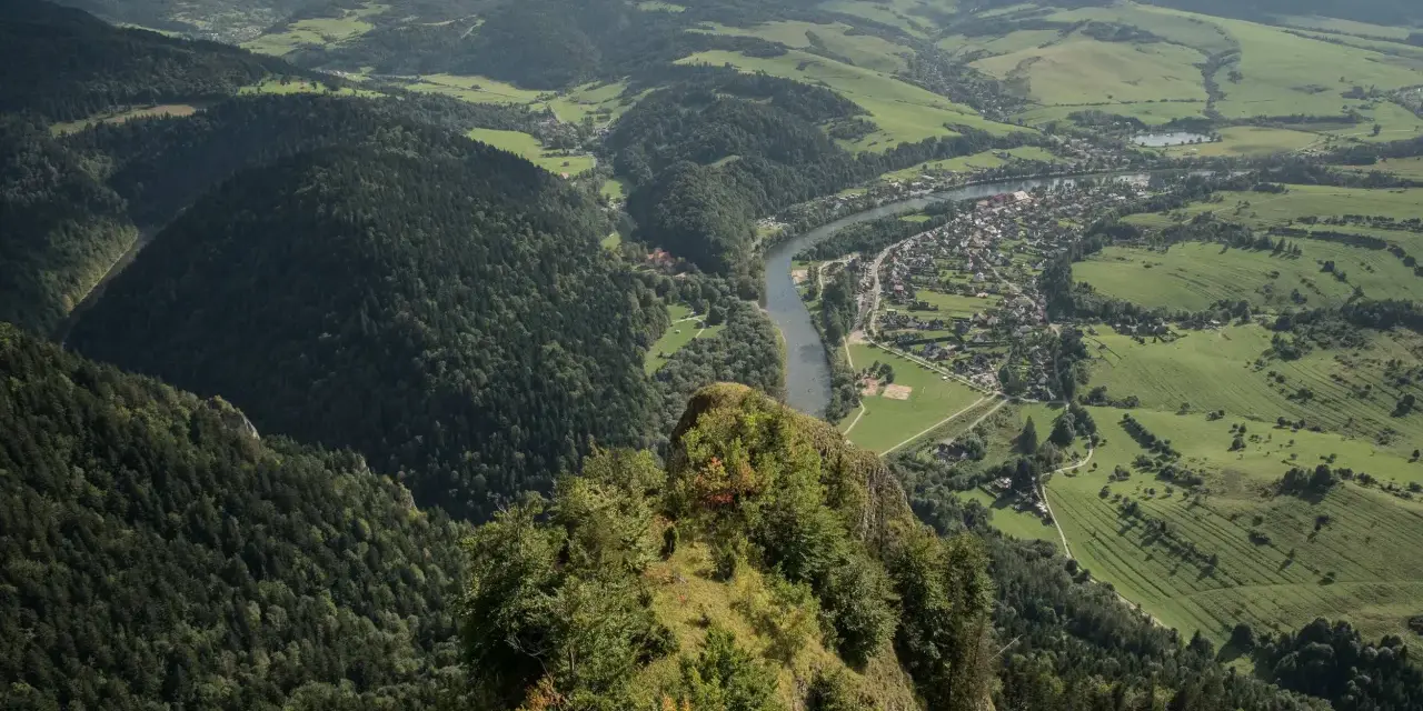 Widok z góry na dolinę Dunajca, miasteczko i zielone wzgórza. Trzy Korony zachwycają, a pytanie "ile się idzie" nabiera sensu, patrząc na tę panoramę.