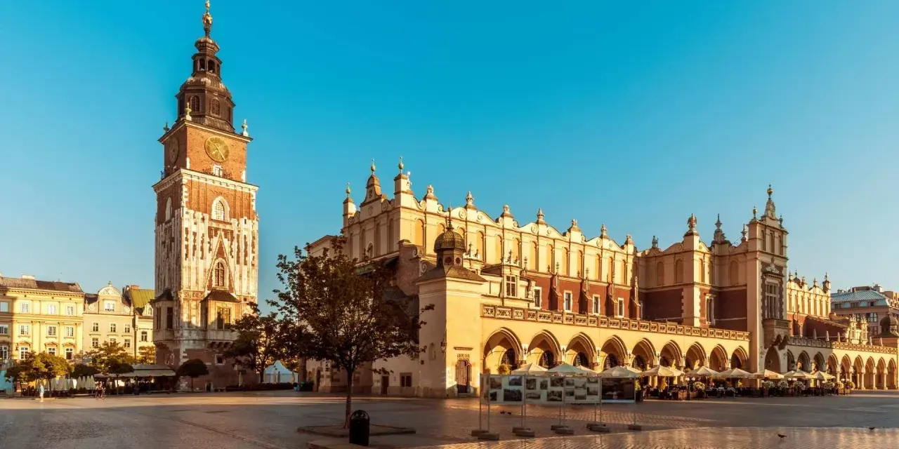 Rynek Główny w Krakowie, idealne miejsce na city break. Sukiennice i wieża Ratuszowa w słońcu.