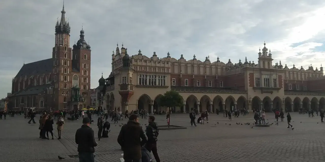 Spacer po Rynku Głównym, sercu historycznego centrum Krakowa. W tle Bazylika Mariacka i Sukiennice.