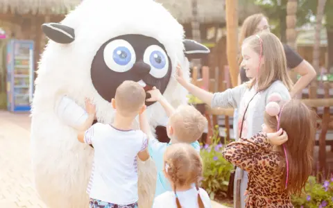 Dzieci bawią się z pluszową owcą, spędzając wesoły weekend z dzieckiem w Polsce.
