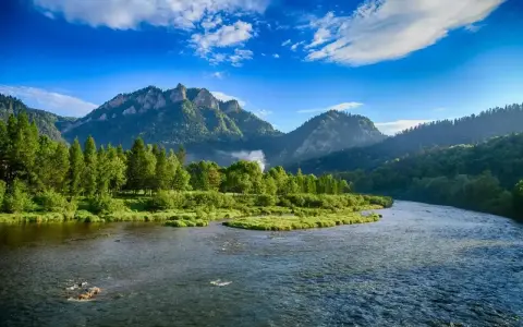 Malowniczy Dunajec w Pieninach, idealne miejsce na wakacje. Góry, lasy i błękitne niebo tworzą bajkowy krajobraz.