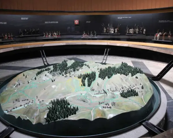 Model terenu przedstawiający bitwę pod Racławicami. Na tle miniatury żołnierzyków w historycznych strojach.