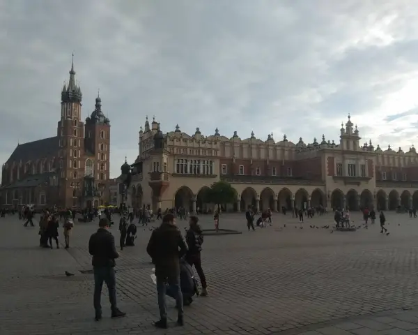Spacer po Rynku Głównym, sercu historycznego centrum Krakowa. W tle Bazylika Mariacka i Sukiennice.