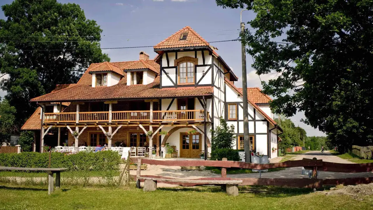 Urokliwa agroturystyka z końmi. Dom w stylu szachulcowym z drewnianą werandą, otoczony zielenią. Idealne miejsce na wypoczynek.