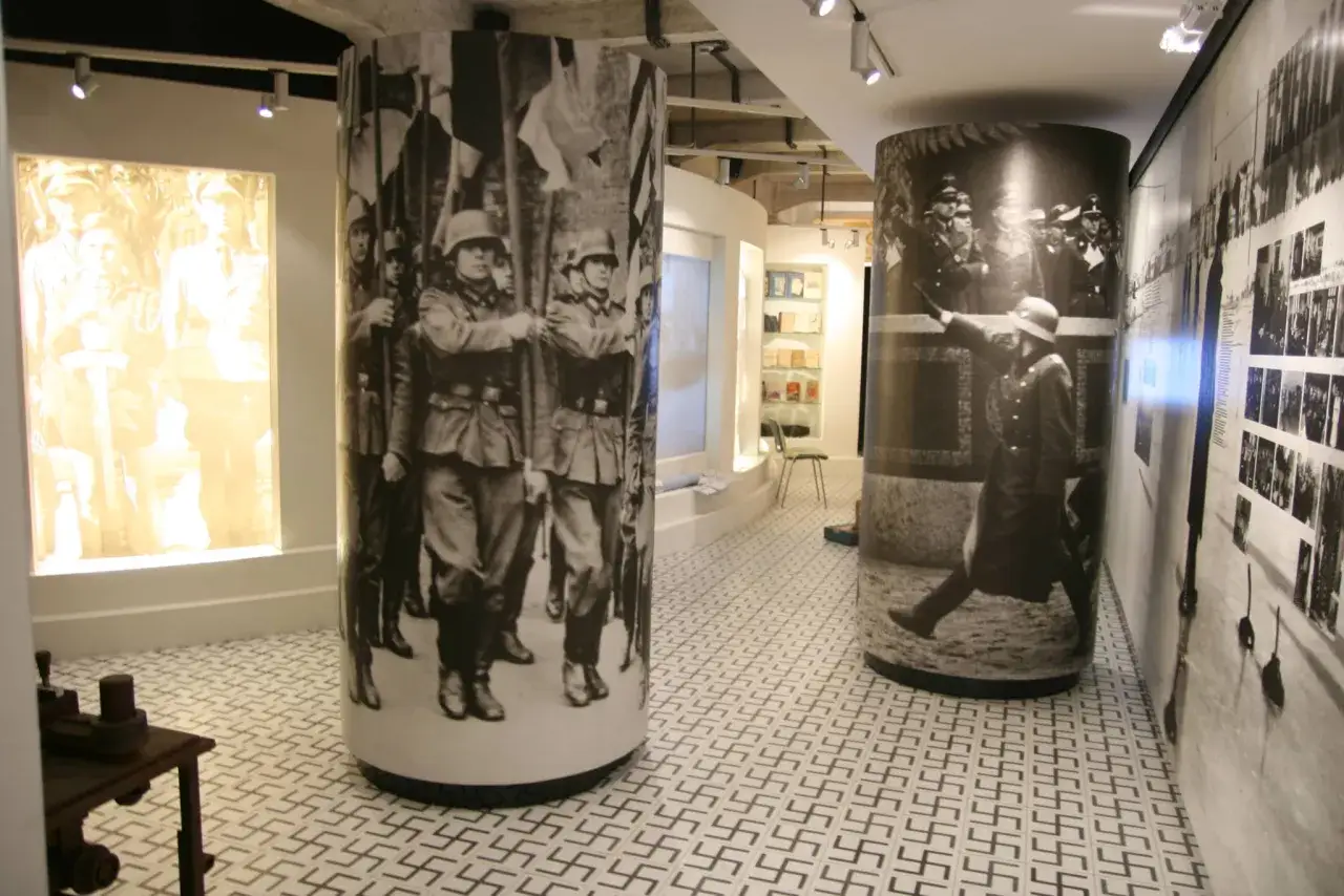 Wystawa w Fabryce Schindlera: monumentalne fotografie żołnierzy i nazistowskich symboli na podłodze.