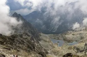 Widok na szlak turystyczny i jeziora w Tatrach, w oddali majaczy schronisko pod Rysami.