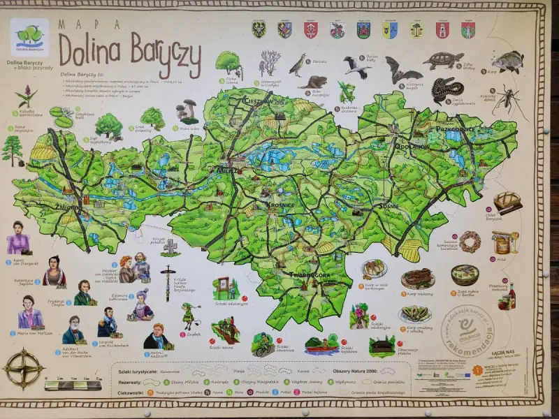 Mapa Doliny Baryczy, ukazująca atrakcje przyrodnicze i kulturowe, w tym stawy, lasy, zabytki i lokalne potrawy.